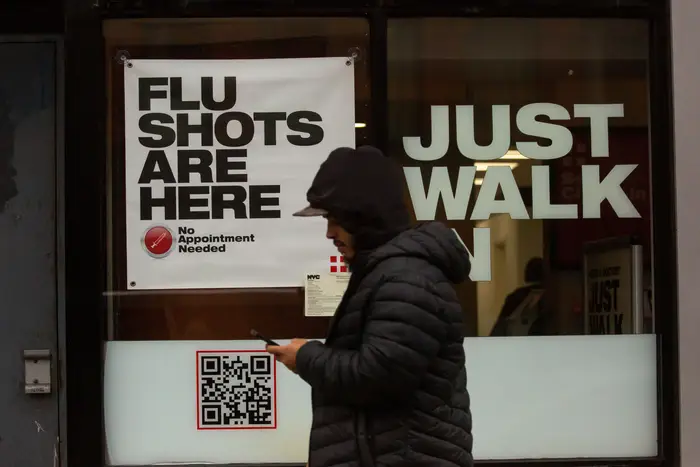 A man walks past an urgent care facility offering flu shots in New York City, Dec. 7, 2022.